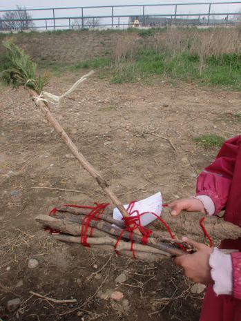 Eine Person, deren Gesicht nicht sichtbar ist, hält ein Bündel Stöcke zusammengebunden.