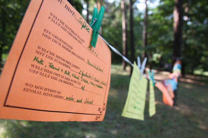 Eine Schnur, an der bunte Papieranhänger mit Texten hängen